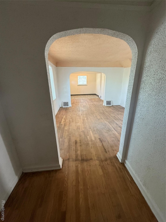 1226 E Princeton Ave, Flint, MI 48505 - hallway featuring arched walkways and wood finished floors