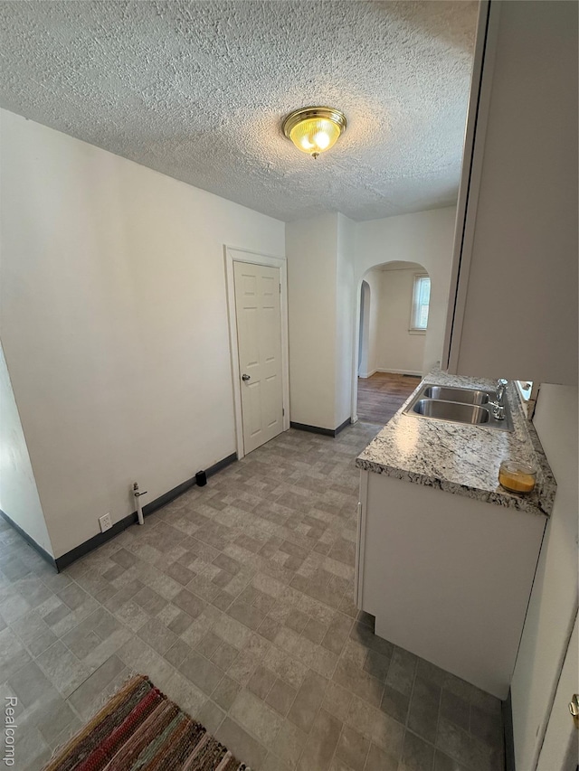 1226 E Princeton Ave, Flint, MI 48505 - kitchen featuring arched walkways, light countertops, and a textured ceiling