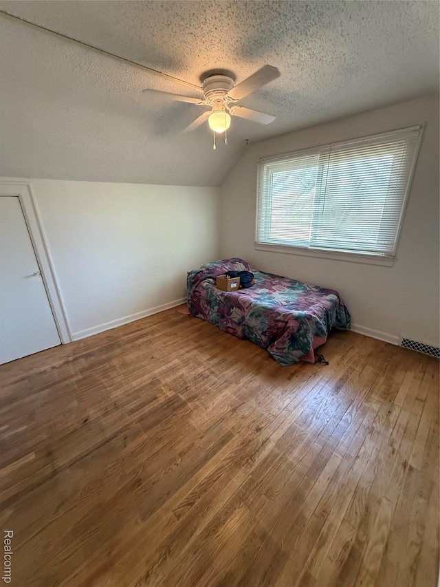 1226 E Princeton Ave, Flint, MI 48505 - bedroom featuring a textured ceiling, lofted ceiling, hardwood / wood-style flooring, and a ceiling fan