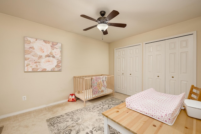 3039 Barclay Way, Ann Arbor, MI 48105 - bedroom featuring multiple closets, carpet, baseboards, a nursery area, and ceiling fan