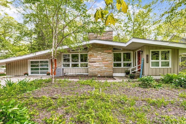 14438 Spring Creek Dr, New Buffalo, MI 49117 - mid-century home with a chimney, board and batten siding, and stone siding