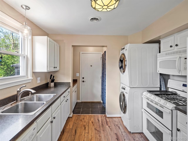 23091 Berdeno Ave, Hazel Park, MI 48030 - kitchen featuring white appliances, stacked washer / dryer, a sink, and dark countertops
