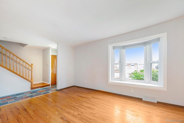 4772 Marian Ave, Warren, MI 48092 - unfurnished living room featuring wood finished floors, stairs, and baseboards