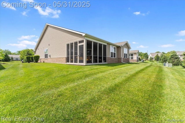 23893 Manistee Ln, Flat Rock, MI 48134 - back of property featuring brick siding, a sunroom, and a yard
