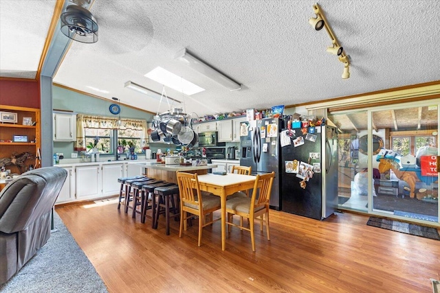 1818 E 58th St, Newaygo, MI 49337 - dining room featuring a skylight, healthy amount of natural light, a textured ceiling, light wood-type flooring, and track lighting