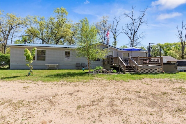 1818 E 58th St, Newaygo, MI 49337 - rear view of property with a deck, a yard, and metal roof