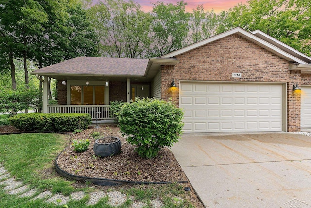 28 Barrington Cir, Saginaw, MI 48603 - view of front facade featuring brick siding, a garage, concrete driveway, and covered porch