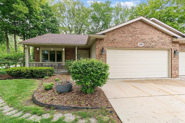 28 Barrington Cir, Saginaw, MI 48603 - single story home with brick siding, a garage, driveway, covered porch, and roof with shingles