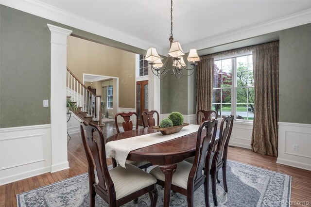 5687 Stonehaven Blvd, Rochester, MI 48306 - dining area featuring a wainscoted wall, a decorative wall, a chandelier, wood finished floors, and crown molding