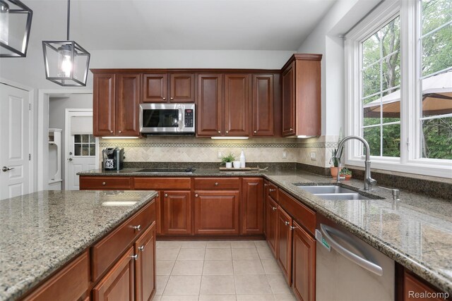 5687 Stonehaven Blvd, Rochester, MI 48306 - kitchen with a sink, stainless steel appliances, dark stone countertops, and plenty of natural light