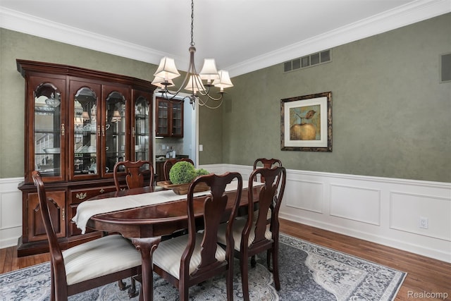 5687 Stonehaven Blvd, Rochester, MI 48306 - dining area with a chandelier, wood finished floors, ornamental molding, wainscoting, and a decorative wall