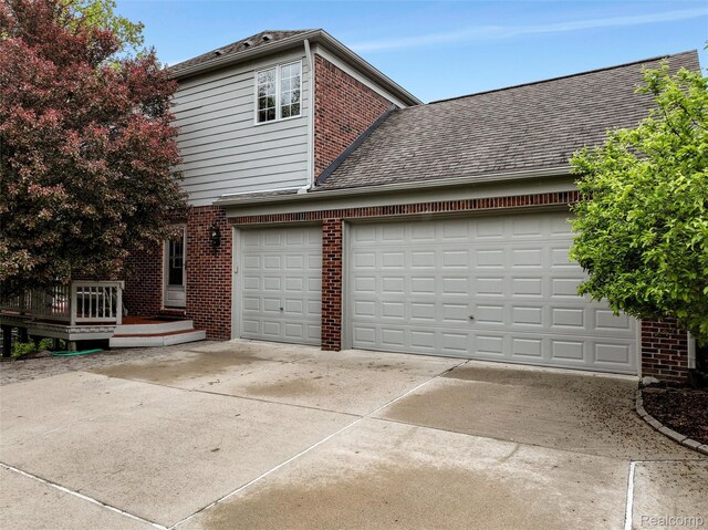 5687 Stonehaven Blvd, Rochester, MI 48306 - view of side of home with driveway, brick siding, an attached garage, and a shingled roof
