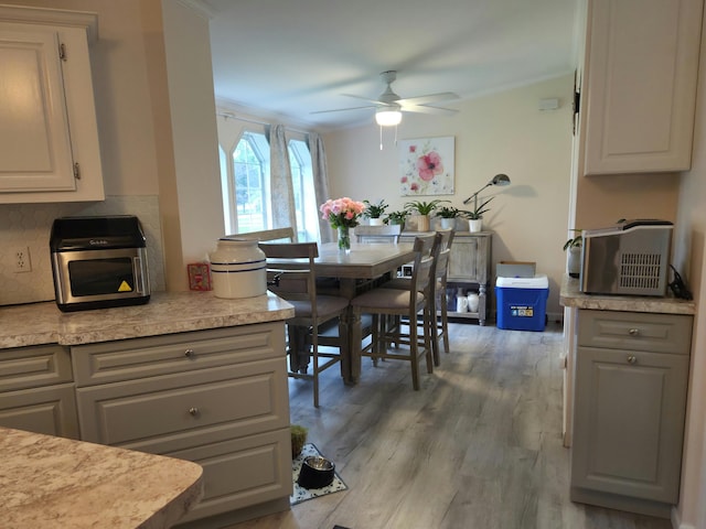 25893 Clark St, Novi, MI 48375 - kitchen featuring a ceiling fan, light countertops, light wood-type flooring, tasteful backsplash, and white cabinetry