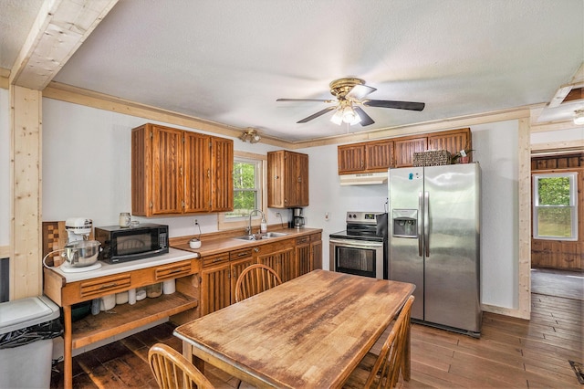 11676 Whitefish Rd, Newaygo, MI 49337 - kitchen with appliances with stainless steel finishes, under cabinet range hood, hardwood / wood-style floors, brown cabinets, and a textured ceiling
