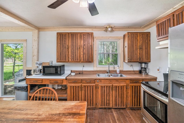 11676 Whitefish Rd, Newaygo, MI 49337 - kitchen with a sink, stainless steel appliances, brown cabinets, ceiling fan, and under cabinet range hood
