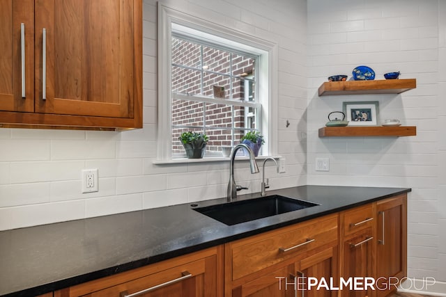 7149 Armadale Ct NE, Belmont, MI 49306 - kitchen featuring a sink, brown cabinetry, decorative backsplash, open shelves, and dark stone countertops