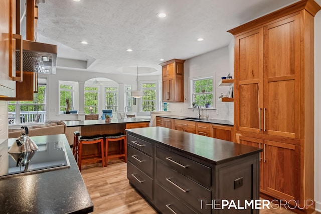7149 Armadale Ct NE, Belmont, MI 49306 - kitchen featuring dark countertops, recessed lighting, a sink, black electric stovetop, and a center island