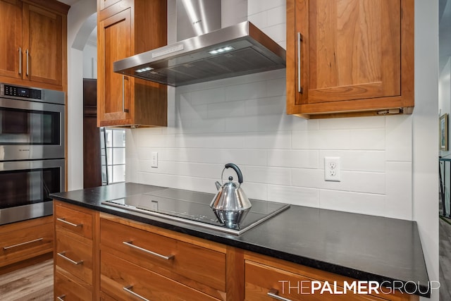7149 Armadale Ct NE, Belmont, MI 49306 - kitchen featuring wall chimney exhaust hood, stainless steel double oven, black electric cooktop, and brown cabinets