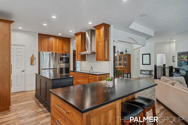 7149 Armadale Ct NE, Belmont, MI 49306 - kitchen featuring a center island, appliances with stainless steel finishes, wall chimney exhaust hood, dark countertops, and open floor plan