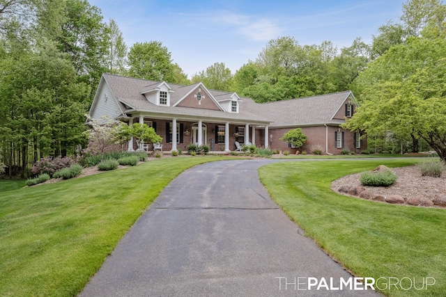7149 Armadale Ct NE, Belmont, MI 49306 - cape cod house featuring covered porch, brick siding, and a front yard