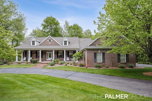 7149 Armadale Ct NE, Belmont, MI 49306 - cape cod house featuring brick siding, a front lawn, and a porch