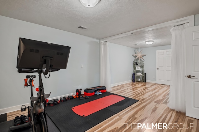 7149 Armadale Ct NE, Belmont, MI 49306 - workout room with light wood-style flooring, a textured ceiling, and baseboards