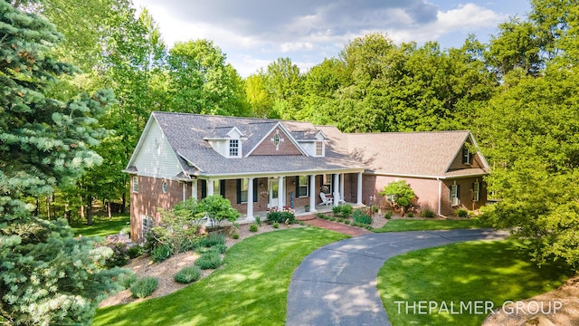 7149 Armadale Ct NE, Belmont, MI 49306 - cape cod home featuring brick siding, a porch, and a front lawn
