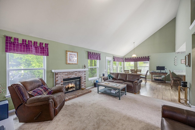 3311 Hickory Dr, Lake Orion, MI 48359 - living area featuring high vaulted ceiling, plenty of natural light, a brick fireplace, baseboards, and carpet floors