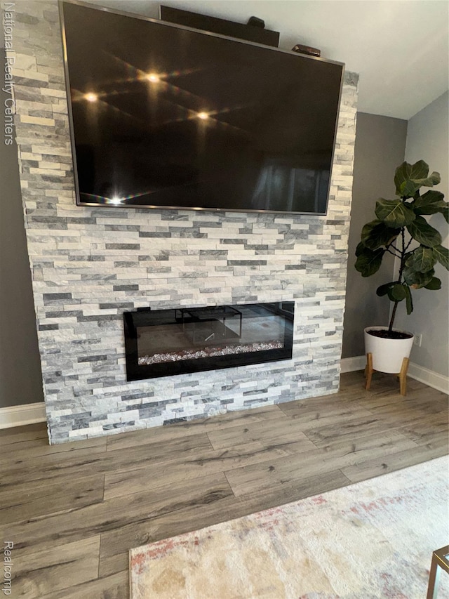 38217 Pinebrook Dr, Sterling Heights, MI 48310 - detailed view of a stone fireplace, baseboards, and wood finished floors