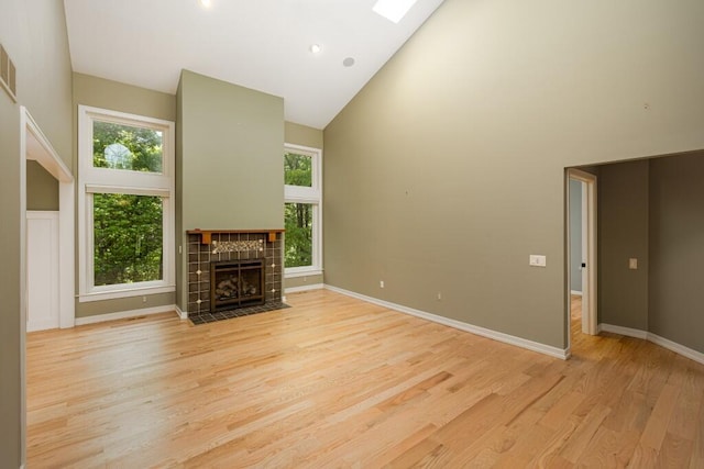 4936 Ravine Ct, Ann Arbor, MI 48105 - unfurnished living room with high vaulted ceiling, plenty of natural light, light wood-type flooring, a fireplace, and baseboards
