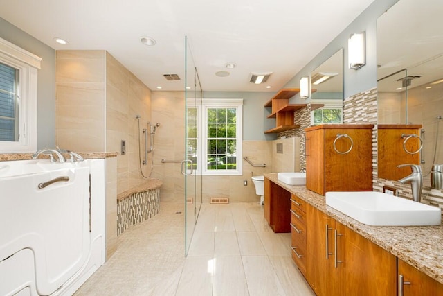 4936 Ravine Ct, Ann Arbor, MI 48105 - full bath with a shower stall, vanity, a garden tub, tile walls, and toilet