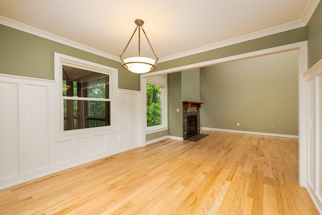 4936 Ravine Ct, Ann Arbor, MI 48105 - unfurnished living room featuring light wood finished floors, a decorative wall, ornamental molding, a fireplace, and wainscoting