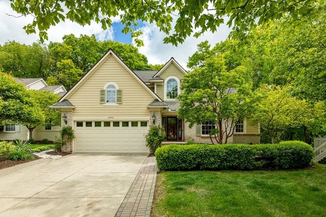4936 Ravine Ct, Ann Arbor, MI 48105 - traditional-style house featuring concrete driveway, a front yard, a garage, and brick siding