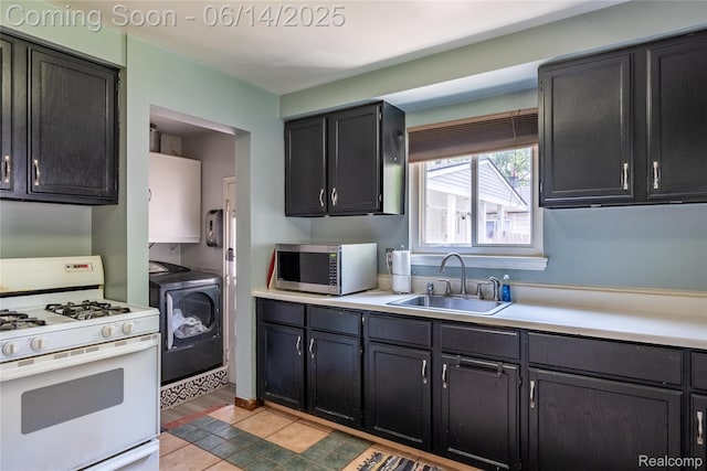 5633 Detroit St, Flat Rock, MI 48125 - kitchen with stainless steel microwave, white gas stove, independent washer and dryer, light countertops, and dark cabinetry
