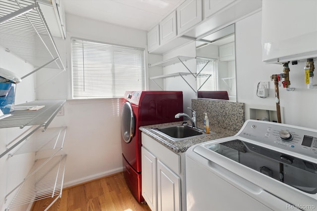 2562 Downing St, Melvindale, MI 48122 - washroom with water heater, light wood-type flooring, cabinet space, and washing machine and clothes dryer