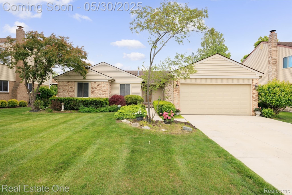 1194 Paddington Rd, Canton, MI 48187 - view of front of house with a garage, brick siding, driveway, and a front lawn