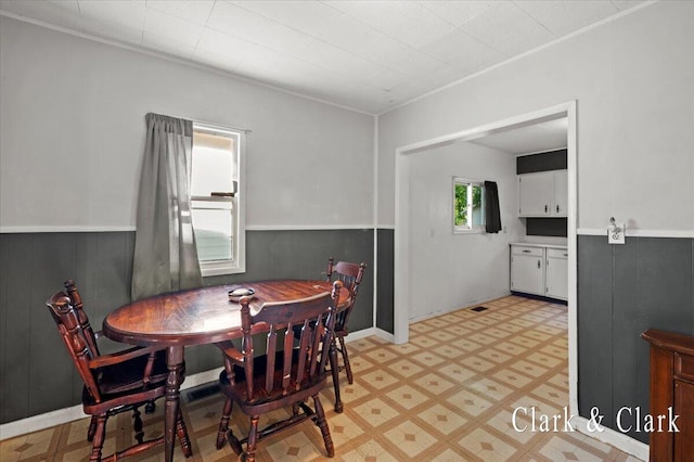 902 Turner Ave, Muskegon, MI 49442 - dining space with light flooring, wainscoting, wood walls, and crown molding