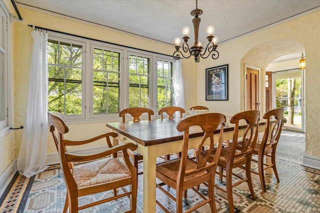 10251 Smith Rd, Union Pier, MI 49129 - dining area with a textured wall, arched walkways, a textured ceiling, a chandelier, and baseboards