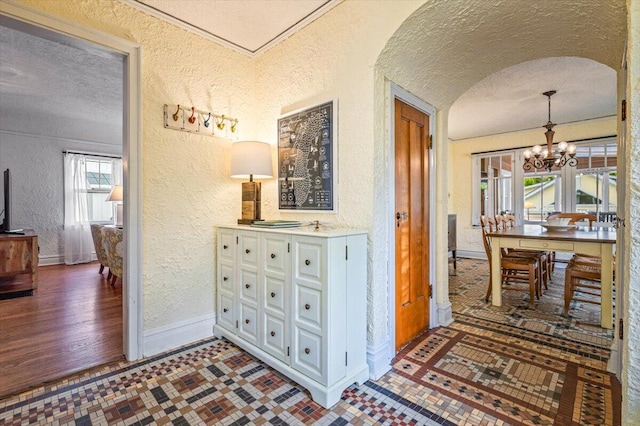 10251 Smith Rd, Union Pier, MI 49129 - corridor with a textured wall, baseboards, a chandelier, and a textured ceiling