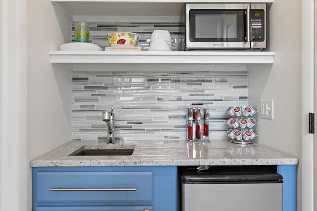 10251 Smith Rd, Union Pier, MI 49129 - indoor wet bar featuring stainless steel microwave, backsplash, and refrigerator