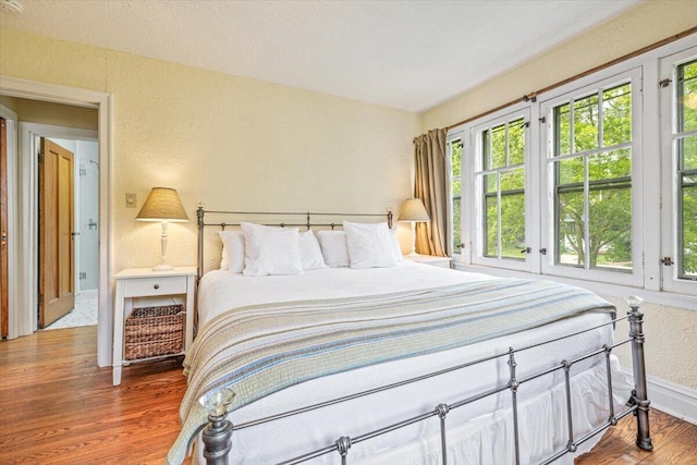10251 Smith Rd, Union Pier, MI 49129 - bedroom featuring multiple windows, wood finished floors, baseboards, and a textured wall