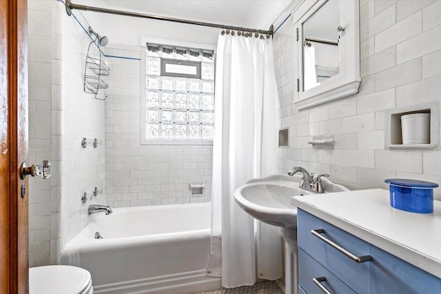 10251 Smith Rd, Union Pier, MI 49129 - bathroom featuring shower / bath combo with shower curtain, toilet, a sink, tile walls, and backsplash