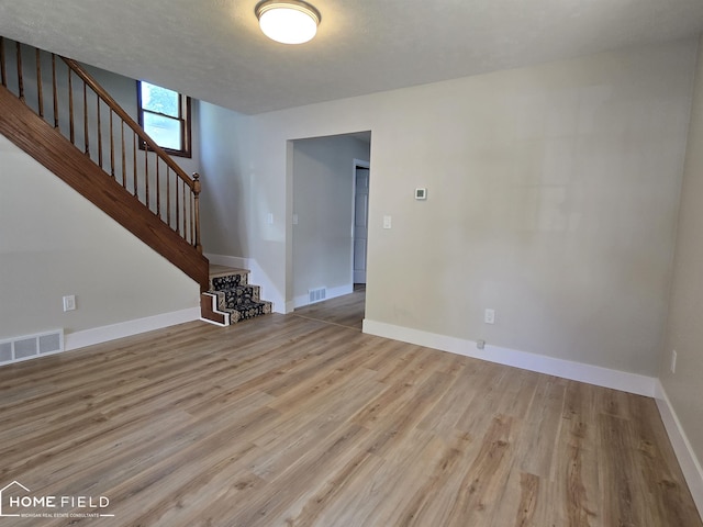 532 Grover St, Owosso, MI 48867 - unfurnished room with stairway, wood finished floors, and baseboards