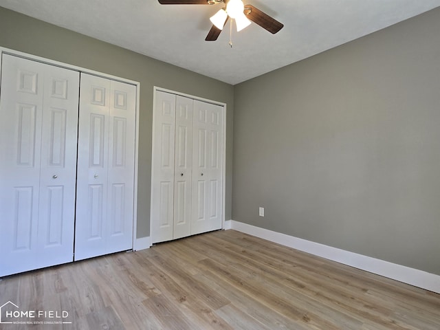 532 Grover St, Owosso, MI 48867 - unfurnished bedroom featuring baseboards, multiple closets, and light wood-style floors