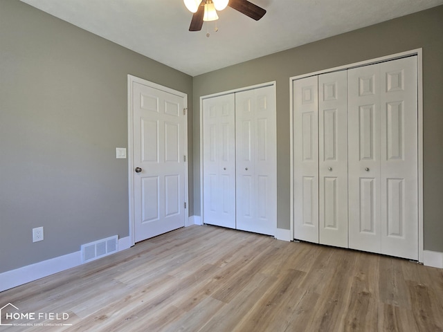 532 Grover St, Owosso, MI 48867 - unfurnished bedroom with multiple closets, baseboards, and light wood finished floors