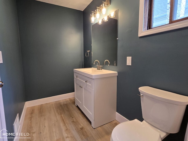 532 Grover St, Owosso, MI 48867 - half bath with vanity, toilet, wood finished floors, and baseboards