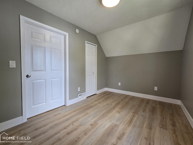 532 Grover St, Owosso, MI 48867 - additional living space with baseboards, wood finished floors, and vaulted ceiling