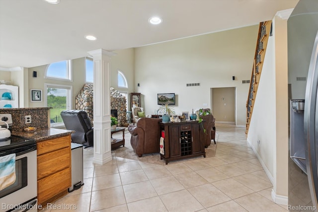 27820 29 Mile Rd, Lenox, MI 48048 - kitchen with ornate columns, appliances with stainless steel finishes, open floor plan, light tile patterned flooring, and a towering ceiling