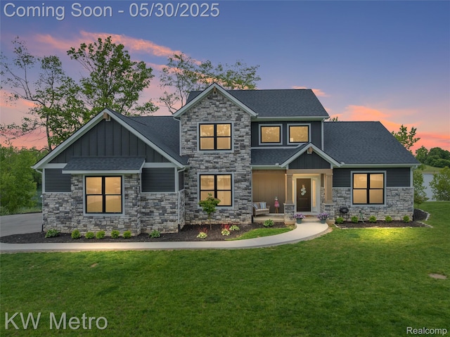1585 Kriss Crossing Rd, Brighton, MI 48114 - view of front facade featuring board and batten siding, stone siding, a lawn, and a shingled roof
