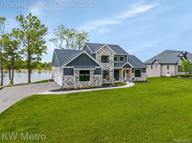 1585 Kriss Crossing Rd, Brighton, MI 48114 - craftsman-style house with board and batten siding, stone siding, concrete driveway, a front yard, and a water view